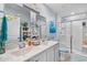 Bright bathroom boasts double sinks, a glass-enclosed shower, and beach-themed decor at 328 Logan St., Little River, SC 29566