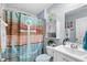 Charming bathroom showcases a decorative shower curtain and traditional vanity at 328 Logan St., Little River, SC 29566