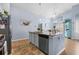 Open concept kitchen features a central island with a sink and seating, modern appliances, and granite countertops at 328 Logan St., Little River, SC 29566