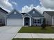 Charming one-story home with a blue exterior, a well-manicured lawn, and an attached two-car garage at 4027 Bucolic Loop, Myrtle Beach, SC 29588