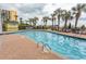 Large outdoor pool surrounded by brick patio, palm trees and lounge chairs at 6804 Ocean Blvd. N # 625, Myrtle Beach, SC 29572