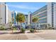 Stunning exterior view of a modern, multi-story resort with bright blue accents and lush landscaping at 7100 N Ocean Blvd. # 405, Myrtle Beach, SC 29572