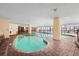 Bright indoor swimming pool with seating area, large pillars, and expansive windows at 7100 N Ocean Blvd. # 405, Myrtle Beach, SC 29572