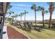 Lounge area with chairs surrounded by palm trees and grass with direct access to the sandy beach at 7100 N Ocean Blvd. # 405, Myrtle Beach, SC 29572