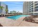 Large outdoor swimming pool surrounded by lounge chairs and tropical palm trees between buildings at 7100 N Ocean Blvd. # 405, Myrtle Beach, SC 29572