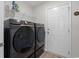 Laundry room with black washer and dryer and overhead shelving at 742 Woodside Dr., Conway, SC 29526