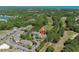 Bird's-eye view of a building complex with lush greenery, a nearby pond, golf course, and distant ocean at 10 Logan Berry Ct. # H, Murrells Inlet, SC 29576