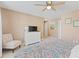 Bright and airy bedroom with plush chair, dresser, tropical art, and neutral colors at 10 Logan Berry Ct. # H, Murrells Inlet, SC 29576