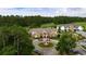 Aerial view of the community clubhouse featuring circle drive, landscaping, and surrounding wooded areas at 10 Logan Berry Ct. # H, Murrells Inlet, SC 29576