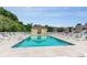 A community pool surrounded by lounge chairs, trees, and a pool house for relaxation and enjoyment at 110 Portsmith Dr. # 8, Myrtle Beach, SC 29588