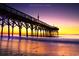 Picturesque pier at sunset, featuring the structure silhouetted against the colorful sky reflecting in the water at 110 Portsmith Dr. # 8, Myrtle Beach, SC 29588