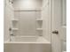 Bright bathroom featuring a clean white bathtub with a shower head and storage niches, perfect for relaxation at 147 Marsh Deer Place, Surfside Beach, SC 29575