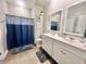 Bathroom with double vanity, tile floor, and a blue shower curtain at 147 Marsh Deer Place, Surfside Beach, SC 29575