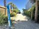 Sandy beach access path for golf carts, lined with lush greenery and palm trees at 147 Marsh Deer Place, Surfside Beach, SC 29575