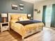 Cozy bedroom with a wooden bed frame, wood flooring, and natural light at 147 Marsh Deer Place, Surfside Beach, SC 29575