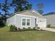 Well-maintained home with a lush green lawn, colorful flowerbeds, and a convenient two-car garage at 147 Marsh Deer Place, Surfside Beach, SC 29575