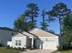 Charming single-story home featuring a manicured lawn, beautiful landscaping, and a two-car garage at 147 Marsh Deer Place, Surfside Beach, SC 29575