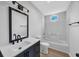 Bathroom features a white shower/tub, toilet, and vanity sink with mirror at 202 Berkshire Dr., Myrtle Beach, SC 29588