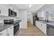 Updated kitchen featuring modern stainless steel appliances, white cabinets, and elegant granite countertops at 202 Berkshire Dr., Myrtle Beach, SC 29588