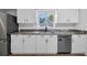 Bright kitchen featuring a stainless steel dishwasher, granite counters, white cabinets, and a window with a view at 202 Berkshire Dr., Myrtle Beach, SC 29588