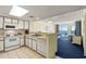 Functional kitchen featuring white appliances and adjacent living area with ocean view at 2711 S Ocean Blvd. # 621, North Myrtle Beach, SC 29582