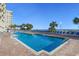 Large outdoor pool with lounge chairs, palm trees, and views of the ocean and clear blue sky at 2711 S Ocean Blvd. # 621, North Myrtle Beach, SC 29582