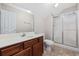 Well-lit bathroom features a shower, toilet, and vanity with warm wood cabinets and neutral walls at 293 Hillsborough Dr., Conway, SC 29526