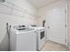 Modern laundry room with white washer and dryer, wire shelving, and a tiled floor at 351 Logan St., Little River, SC 29566