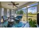 Cozy screened-in porch with wicker furniture, ceiling fan, and views of the well-maintained yard at 351 Logan St., Little River, SC 29566