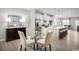 Open-concept dining area with a glass table, four chairs, and views of the modern kitchen at 439 Myrtle Meadows Dr, Conway, SC 29526