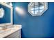 Stylish blue powder room featuring a unique mirror and an octagonal window at 4504 S Ocean Blvd. # A, North Myrtle Beach, SC 29582
