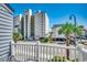 Condo balcony view of the building and street, with palm trees and clear blue sky at 4504 S Ocean Blvd. # A, North Myrtle Beach, SC 29582