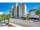 Beach Club III exterior featuring a well-maintained building, palm trees, and ample parking at 4504 S Ocean Blvd. # A, North Myrtle Beach, SC 29582