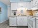 A kitchen area with white cabinets, appliances, light countertops, and modern gray vinyl flooring at 5000 N Ocean Blvd. # B-1, North Myrtle Beach, SC 29582