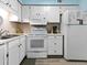 Kitchen area with white appliances and cabinets, neutral countertops, and modern flooring at 5000 N Ocean Blvd. # B-1, North Myrtle Beach, SC 29582