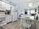 A bright kitchen and dining area featuring white cabinets, appliances and a view into the adjoining living room at 5000 N Ocean Blvd. # B-1, North Myrtle Beach, SC 29582