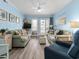 Cozy living room with light-blue walls, comfortable sofas, and access to the outdoor deck at 5000 N Ocean Blvd. # B-1, North Myrtle Beach, SC 29582