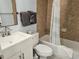 Bathroom showcasing a single sink vanity, tiled shower with shower curtain and stacked towels at 5300 N Ocean Blvd. # 106, Myrtle Beach, SC 29577