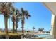 Pool view framed by palm trees with lounge chairs for guests to enjoy the sun and ocean breeze at 5300 N Ocean Blvd. # 106, Myrtle Beach, SC 29577