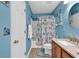 Bright bathroom with a single sink vanity, decorative wall hangings, and a bathtub with shower behind a door at 1046 Palisade Circle # 1046, Myrtle Beach, SC 29577