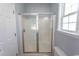 Bathroom shower with glass doors and window, alongside a white toilet at 107 Carolines Cove Ct., Myrtle Beach, SC 29588
