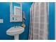 Cozy bathroom featuring a pedestal sink and medicine cabinet against a vibrant blue wall at 1095 Plantation Dr. W # 29 N, Little River, SC 29566
