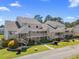 Exterior view of townhomes featuring private entrances and manicured landscaping under a sunny sky at 1095 Plantation Dr. W # 29 N, Little River, SC 29566