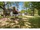A tree-lined backyard has a lawn, patio, and brick home with a chimney at 124 Windmeadows Dr., Conway, SC 29526