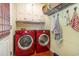Well-lit laundry room featuring a red washer and dryer, storage and tiled floors at 124 Windmeadows Dr., Conway, SC 29526