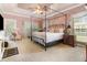 Airy primary bedroom featuring a four-post bed, carpet, a ceiling fan, and large bright windows at 124 Windmeadows Dr., Conway, SC 29526