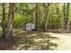 A small storage shed is tucked amongst the trees at the edge of a green lawn at 124 Windmeadows Dr., Conway, SC 29526