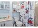 Cozy bathroom with a vanity, toilet, shower/tub with whimsical curtain, and storage cabinet at 1411 Turkey Ridge Rd. # 30-B, Surfside Beach, SC 29575