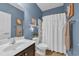 Cozy bathroom with decorative blue walls, dark cabinets, and a full tub and shower at 1512 Virginia Pine Dr., Longs, SC 29568