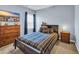 Well-lit bedroom with a TV, natural light, and a wood-framed bed with blue plaid bedding at 1512 Virginia Pine Dr., Longs, SC 29568